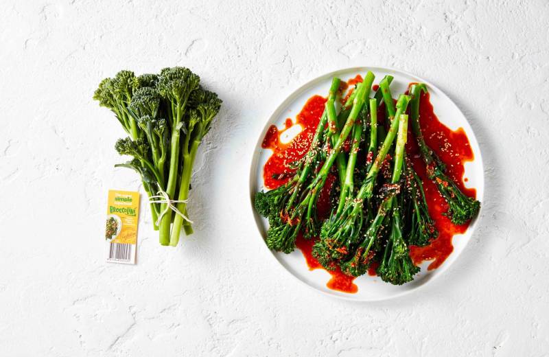 A bed of steamed broccolini® with a red gochujang dressing.